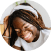 Joyful young african woman laughing sitting on sofa